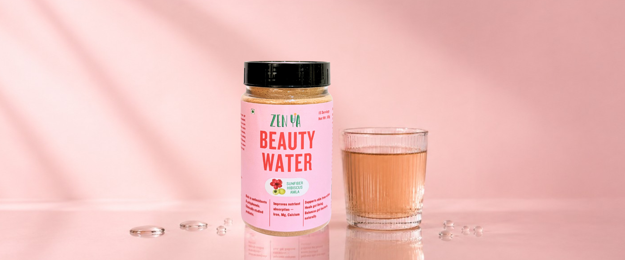 Jar of Zen Ya Beauty water on a pink background with a glass of beauty water next to it 
