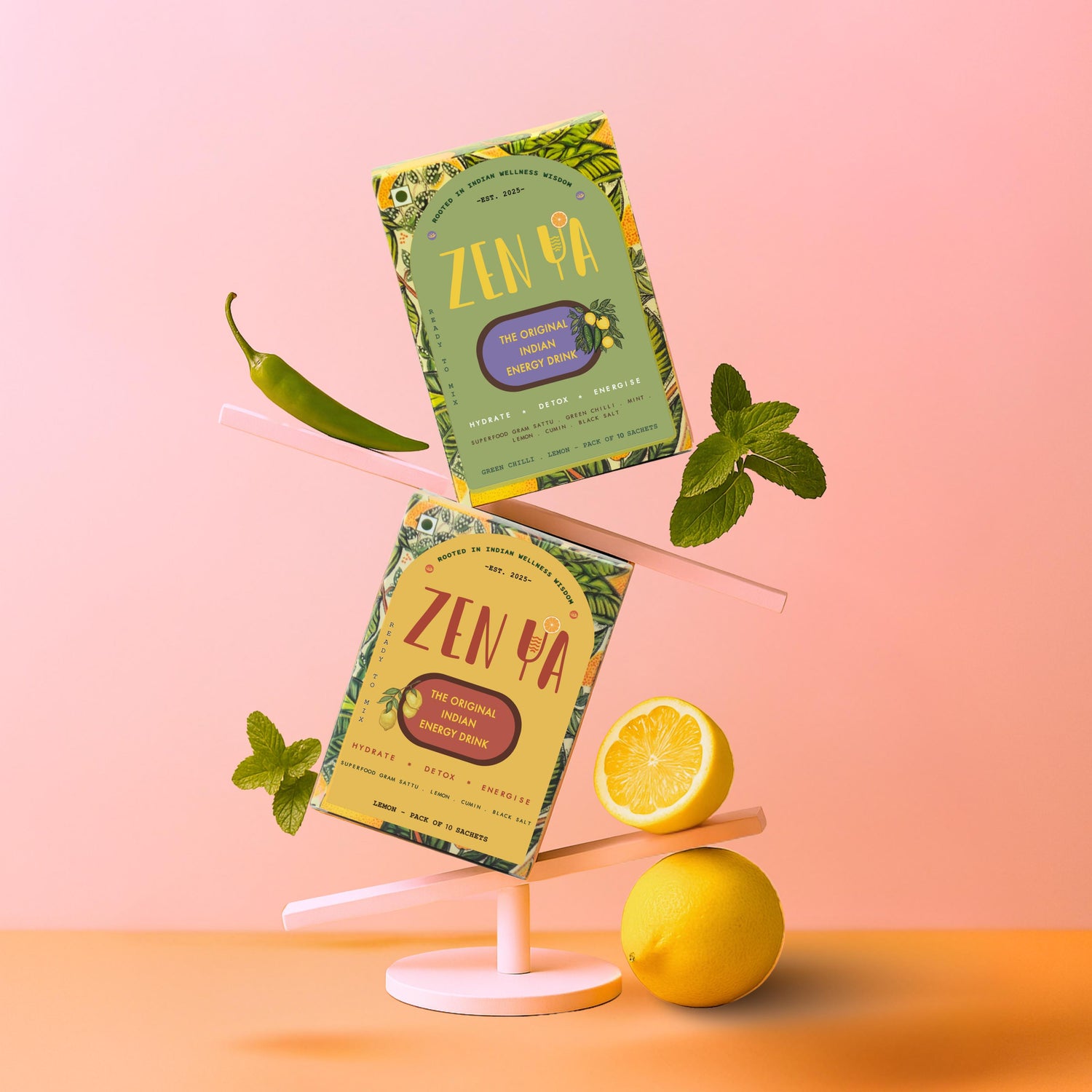 Two vibrant ZenYa energy drink boxes are creatively balanced on a modern white stand against a pastel pink and orange background. One pack is lemon-flavoured and the other is green chilli–lemon. Fresh ingredients like mint leaves, green chilli, and whole and sliced lemons are placed decoratively around the packs, reflecting the natural and bold Indian flavours of the drinks. The packaging highlights the product’s benefits: “Hydrate, Detox, Energise” with superfood sattu, cumin, lemon, and black salt.