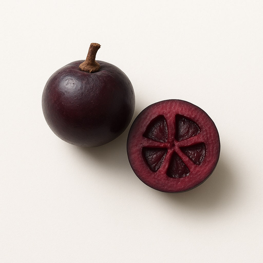 Whole and halved purple kokum fruit on a white background