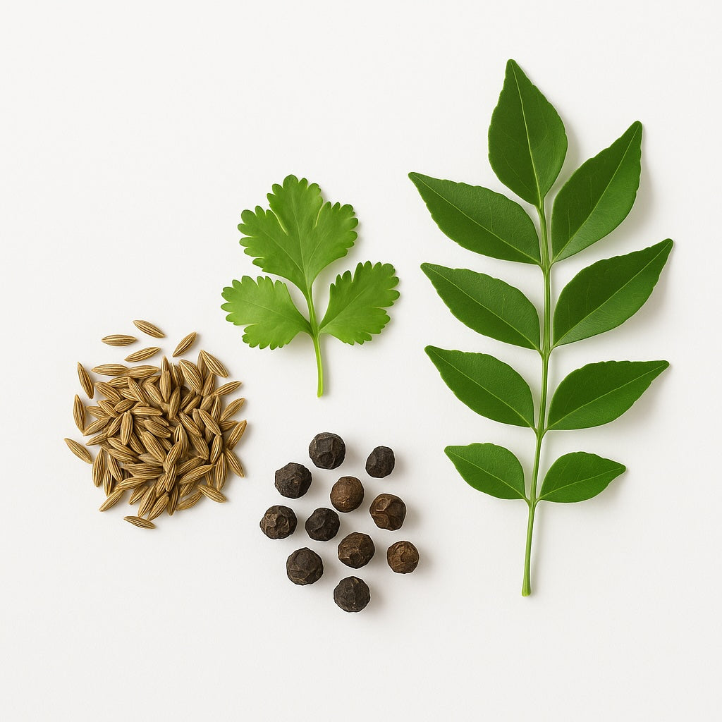 Spices including fennel seeds, black peppercorns, and curry leaves on a white background